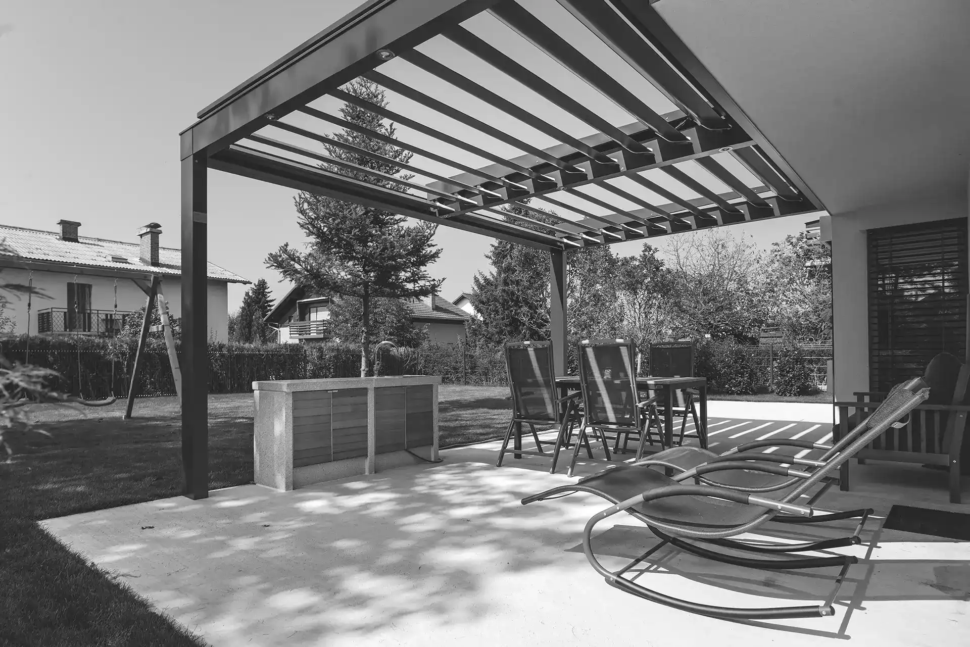 backyard concrete patio covered by pergola